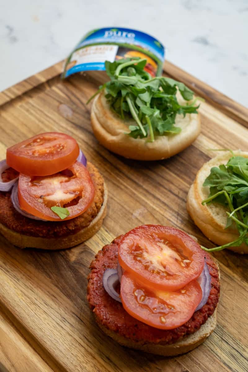 Top with sliced red onion, arugula and tomatoes.