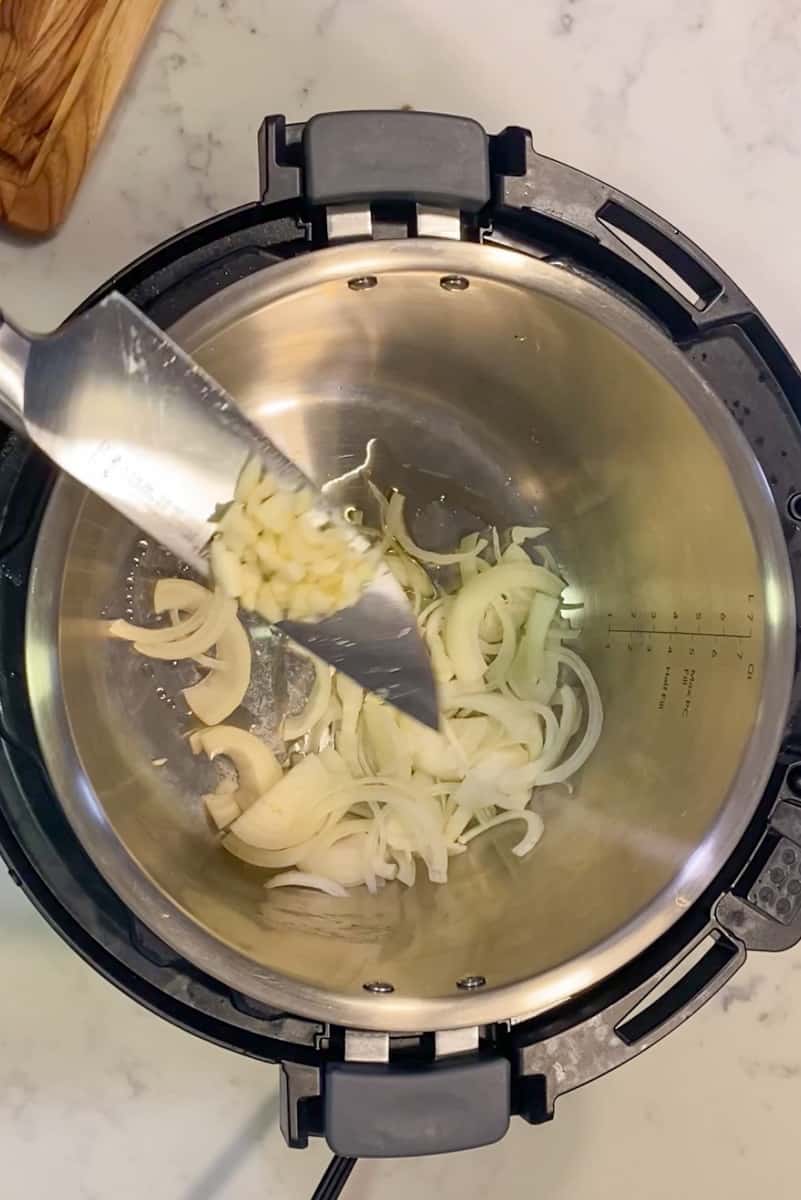 In an instant pot, hit the sauté function for 5 minutes. Add the oil and wait for it to shimmer. Toss the onion and garlic until fragrant.