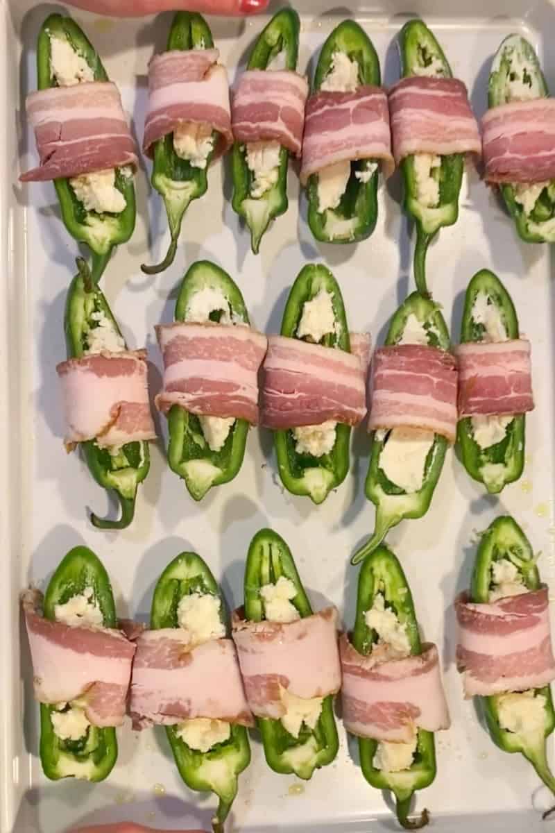 Wrap a piece of bacon around the stuffed pepper half. Repeat with the rest.