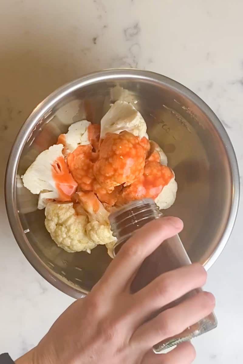 Put the cauliflower in a large bowl and throw in the olive oil, hot sauce, chili powder, pepper, onion powder, and salt and toss. In another bowl, add the bread crumbs and the parmesan cheese.