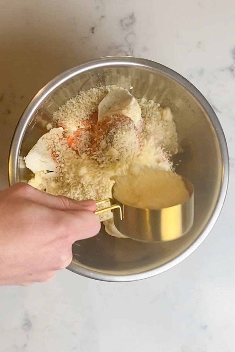 Using the hot sauce mixture as glue, toss the cauliflower in the sauce, then coat with the parmesan-bread crumbs, and place on the baking sheet. Repeat with the rest.