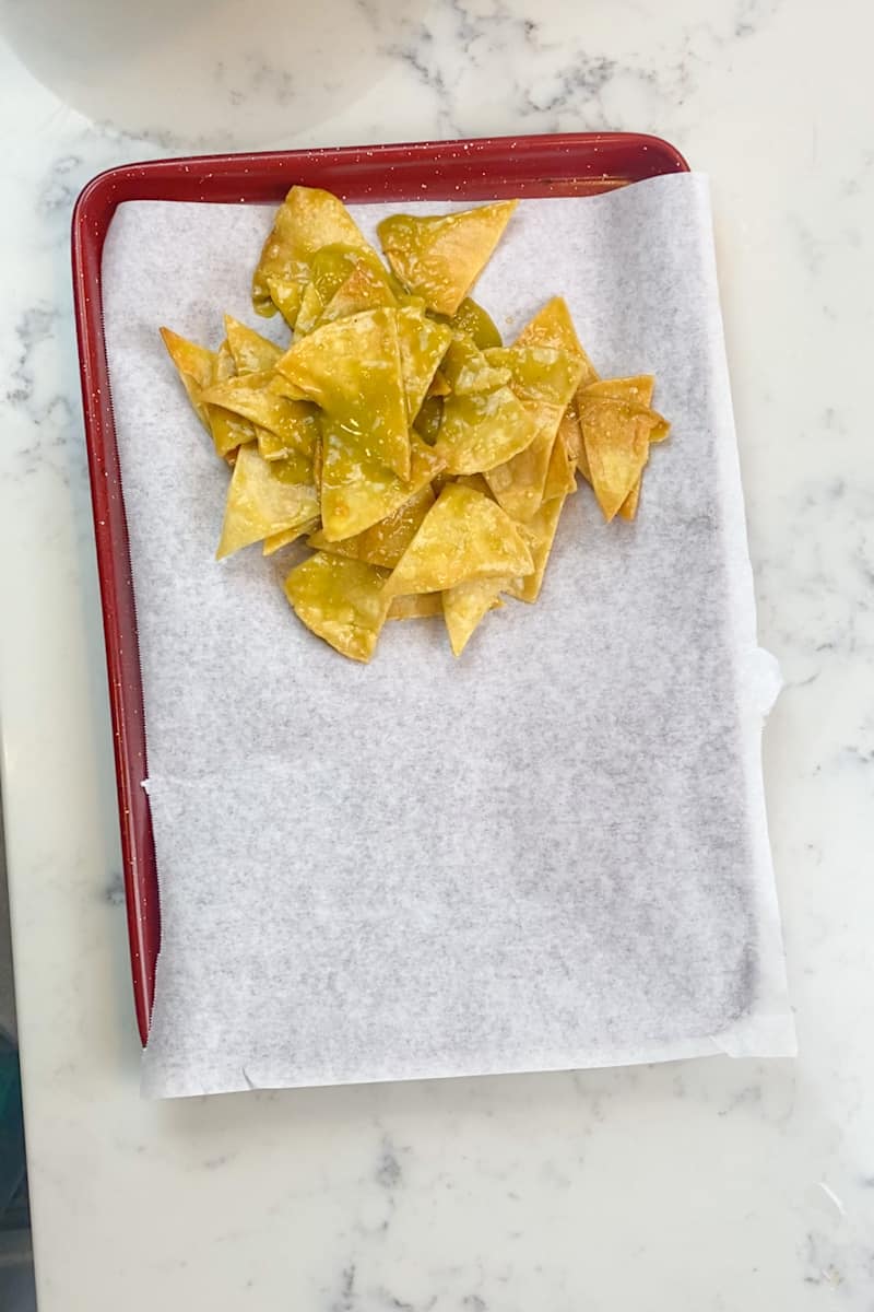 Pat the tortillas dry with a paper towel and split them up into two bowls. In one bowl mix your salsa verde and in the other mix salsa roja. 