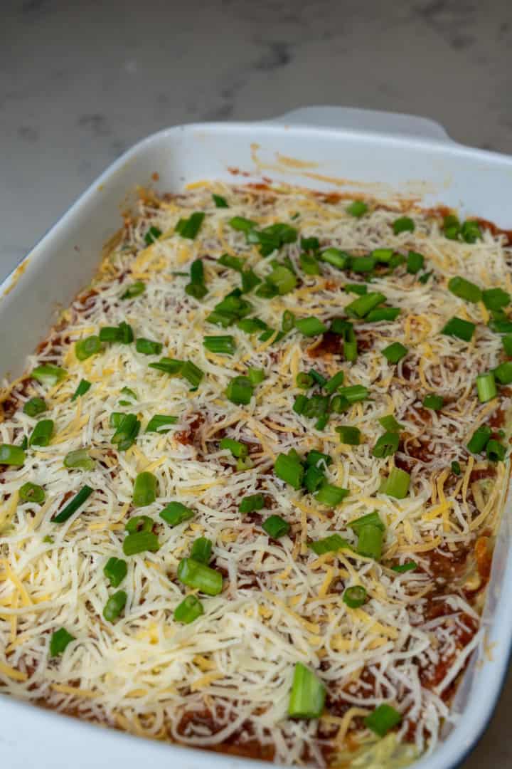 This 7 Layer Dip Recipe is made with salsa, refried beans, cream cheese, sour cream, taco seasoning, guacamole, shredded cheese and green onion.