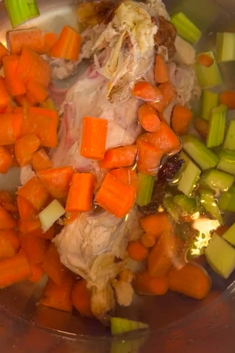 In an instant pot, add the chicken bones, carrots, celery stalks, apple cider vinegar, parsley, bay leaves, peppercorns and season generously with salt. Pour in the water.