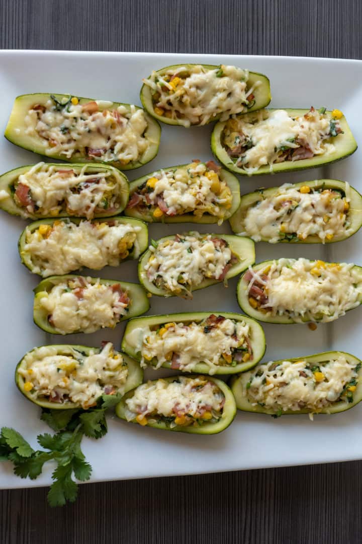 These Keto Zucchini Boats with Bacon are made with bacon, corn, red onion, garlic, cilantro, and filled into zucchinis and baked with melted cheese on top.