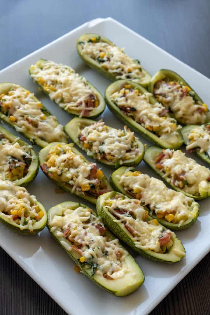 These Keto Zucchini Boats with Ham are made with bacon, corn, red onion, garlic, cilantro, and filled into zucchinis and baked with melted cheese on top.