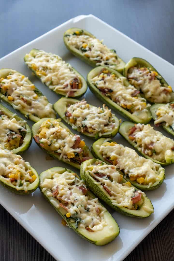 This Zucchini Boats Recipe are made with bacon, corn, red onion, garlic, cilantro, and filled into zucchinis and baked with cheese.