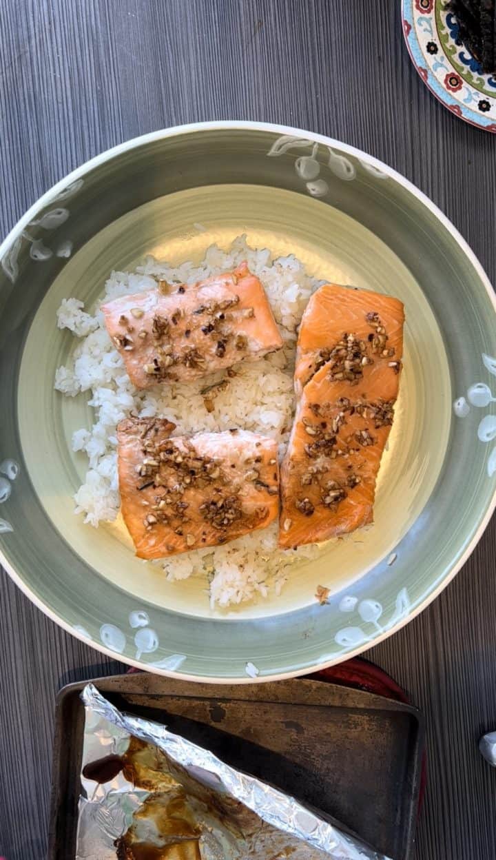 Add the cooked rice into a large bowl. When the salmon is cooked, place the salmon onto the bed of rice. 