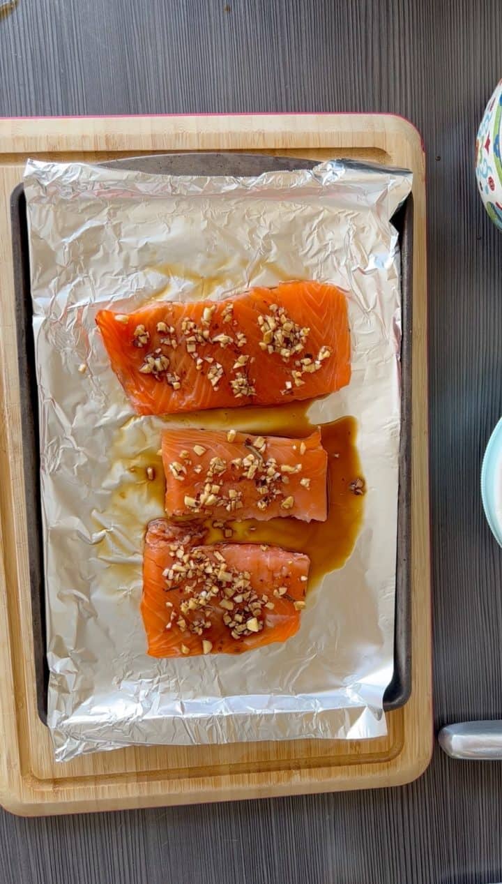 Preheat the oven to 400°F. Make the sauce. Add the ginger, garlic, soy sauce, rice vinegar, sesame oil and red pepper flakes into a bowl and whisk. On a baking sheet lined with aluminum foil add the salmon. Spread the soy sauce mixture onto the salmon. Bake for 12-15 minutes, until cooked.
