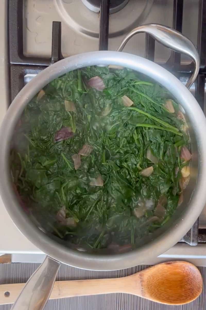 Keep adding more spinach, and keep stirring, until all of the spinach has shriveled. Pour in the vegetable broth and bring the mixture to a boil.
