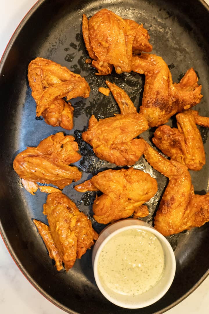 These Truff Hot Sauce Wings are made with chicken wings, baking powder, paprika, Truff hot sauce, butter, and served with ranch on the side.