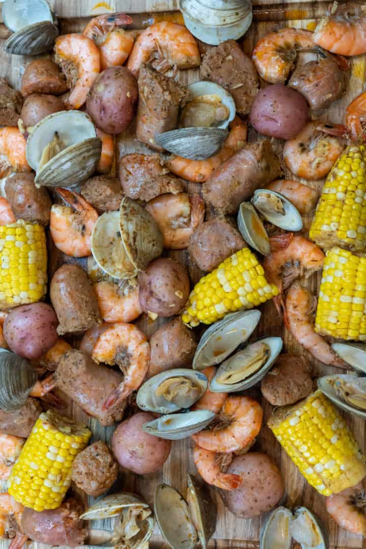 This seafood boil in a bag is made with corn, potatoes, old bay, shrimp, clams, sausage and baked in an oven proof bag.