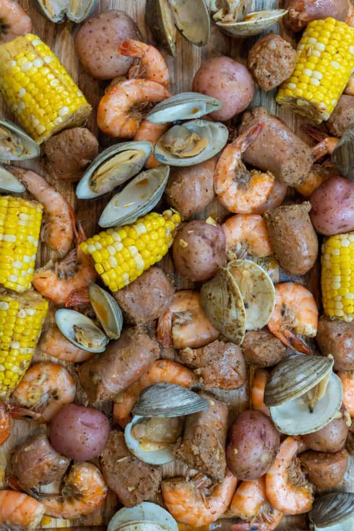 This seafood boil in a bag is made with corn, potatoes, old bay, shrimp, clams, sausage and baked in an oven proof bag.