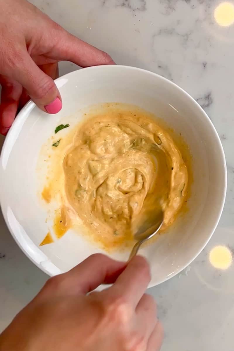 In the same large bowl, add the sour cream, mayonnaise, half the cilantro, half the cheese, hot sauce, and lime juice. Stir to combine.