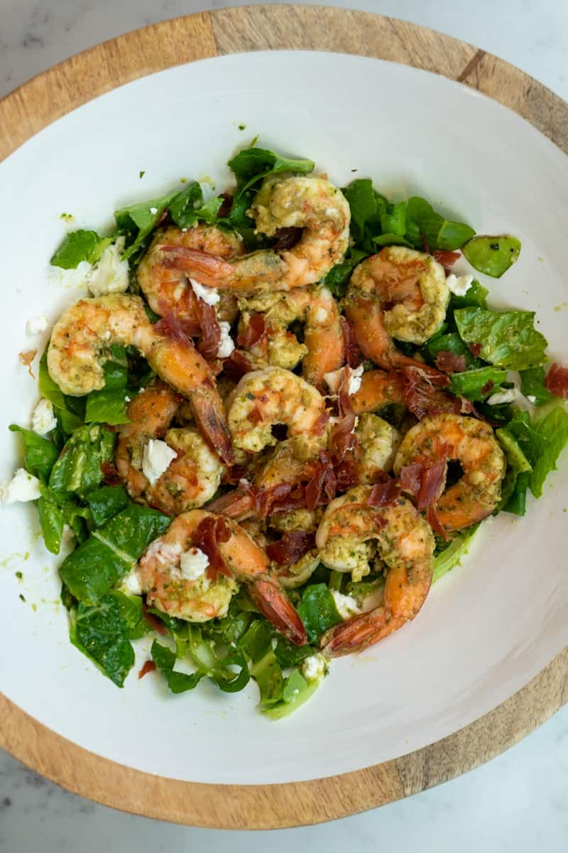 This Shrimp Pesto Salad is made with pesto, vinegar, parmesan cheese, butter, shrimp, goat cheese, lemon, and all tossed in chopped romaine.