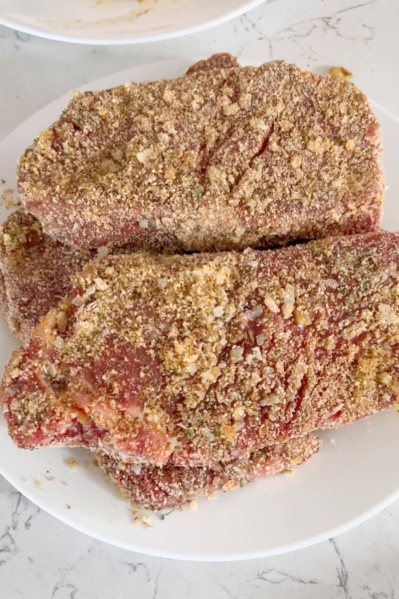 Mix the bread crumbs, cheese, oregano, salt and pepper together in another shallow dish. Remove the steaks from the oil, letting the oil cling to the steaks. Dip each piece of steak into the bread crumb mixture, patting to coat both sides. Let stand 10 minutes to set the crumbs.