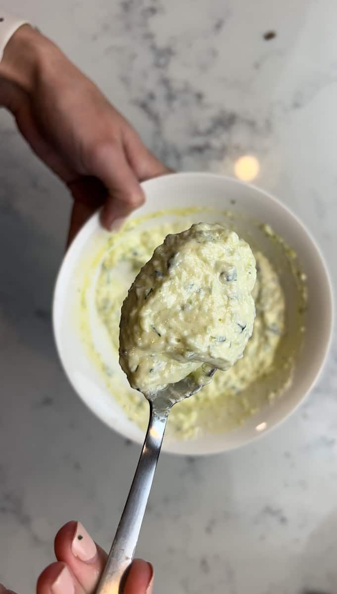 Make the Tzatziki: In a food processor, start by pulsing the cucumber but do not overpulse. Put the cucumber on top of a clean towel and squeeze all that water out. Put to the side.