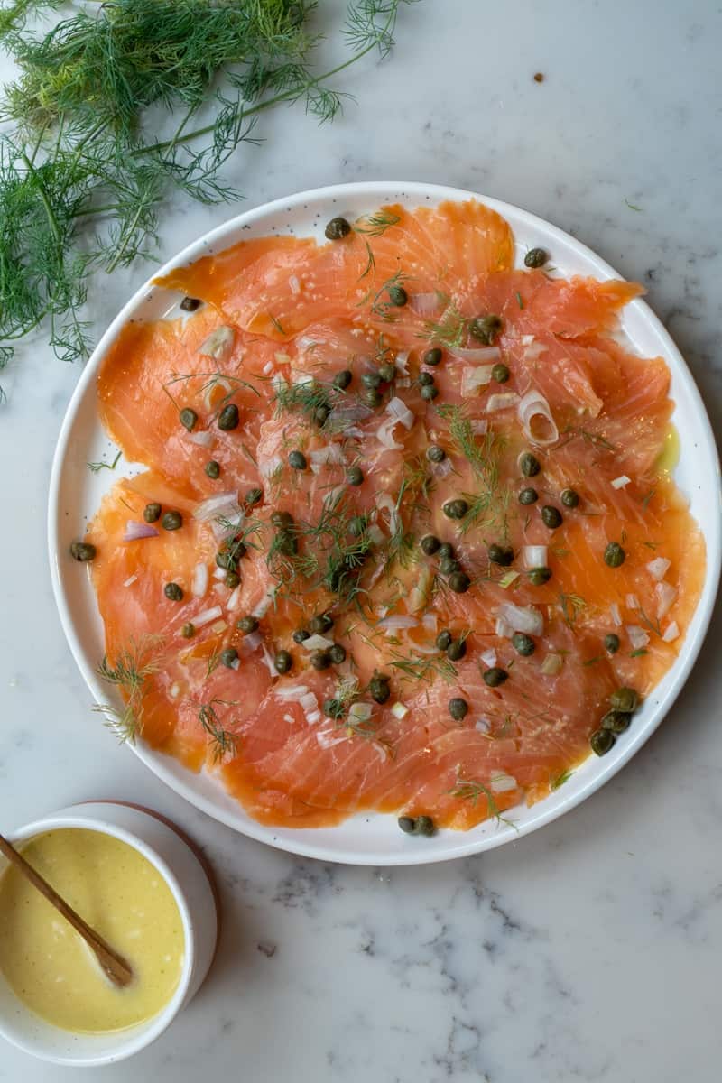 Scatter over the sliced shallot, capers, dill, freshly grated pepper, and salt. Serve with crackers or crostini. Enjoy this Salmon Carpaccio with Capers and Shallots.