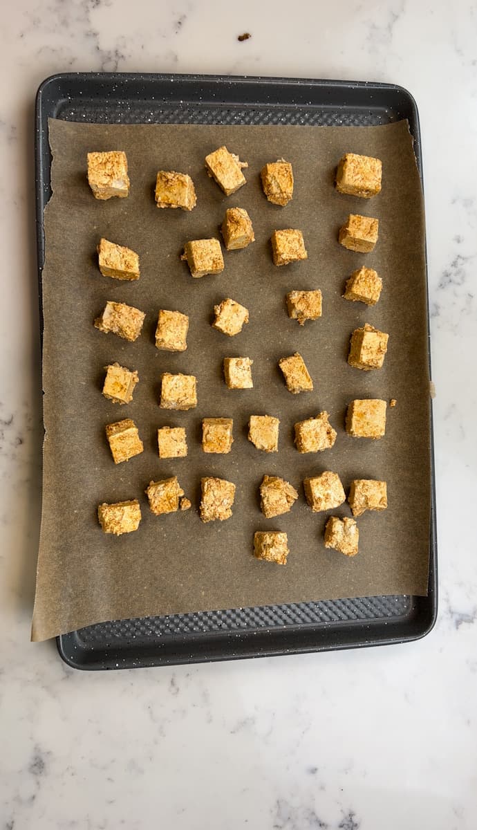 Preheat the oven to 375°F. Line a baking sheet with parchment paper and spray with avocado oil. Spread the tofu evenly across the baking sheet and bake for about 30 minutes, flipping halfway through, until lightly golden.