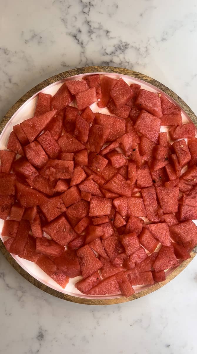 On a large serving plate, arrange the cubed watermelon.
