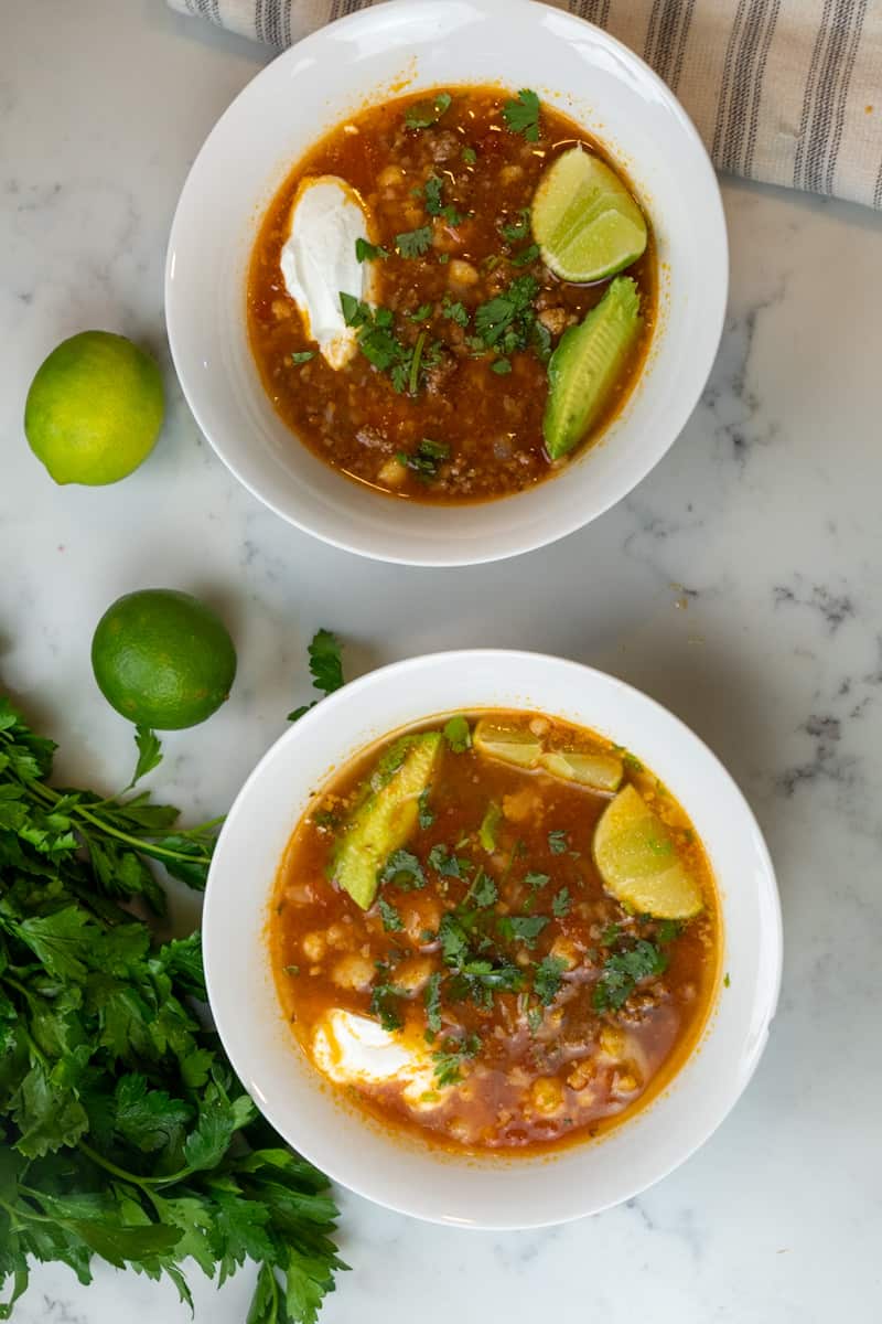 Squeeze lime juice into the pot, combine, and garnish with cilantro, sour cream, or lime wedges.