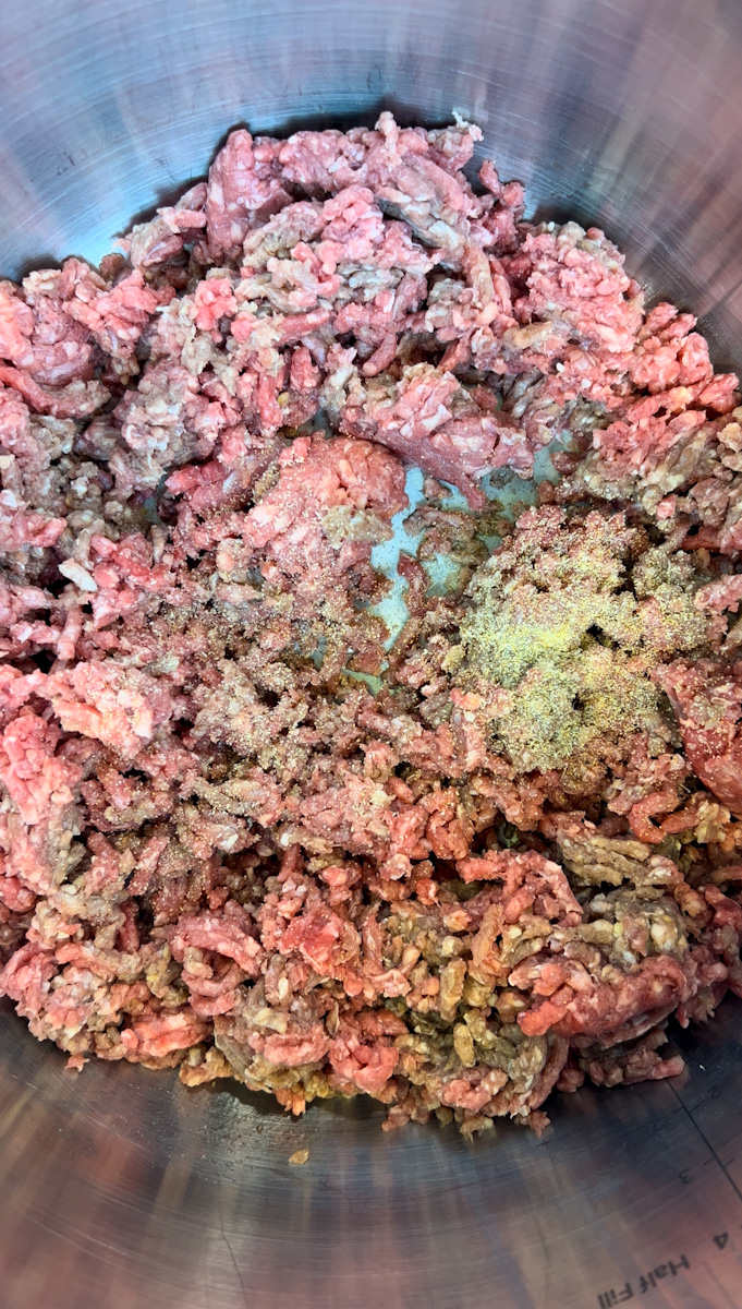 Add olive oil until the oil shimmers. Stir in the ground beef, chili powder, cumin, and oregano, breaking meat apart with a wooden spoon, for 4-5 minutes until brown and broken apart.