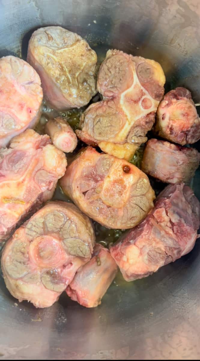 Season oxtails with salt and pepper. Heat a large Dutch oven on high heat. Add brown sugar to pot and melt, stirring with a wooden spoon, until dark. When the sugar is melted, add 2 tablespoons hot water and stir.