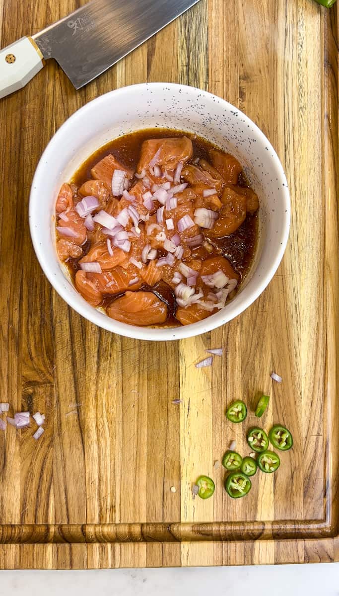 Lay the salmon slices onto a plate scatter the diced shallot and sliced serrano pepper.