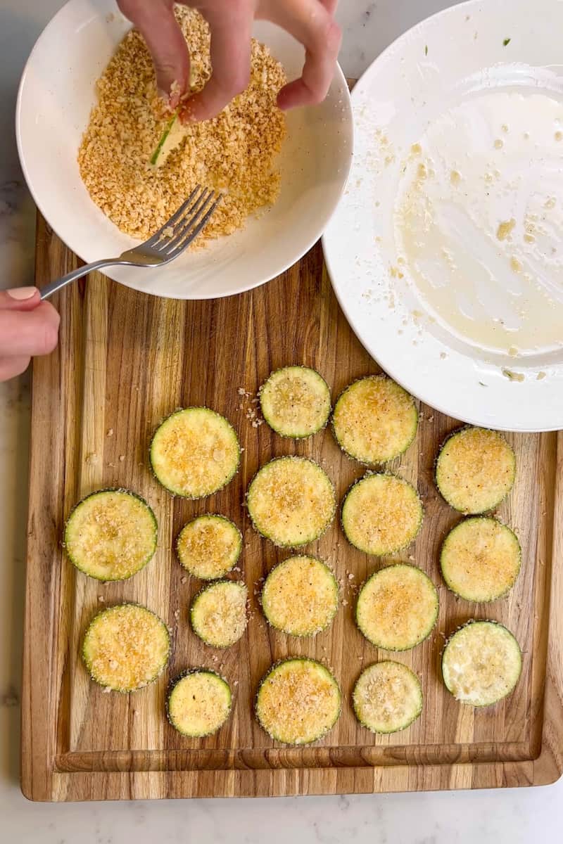 Slice the zucchini into very thin circles.  Spray the sliced zucchini with olive oil spray on both sides. Dip into the panko crumbs. Repeat with the rest.