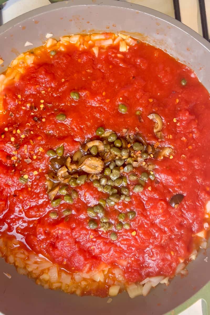 Cook, uncovered, for about 10 minutes. Add the olives, capers, red pepper flakes and cook for another 6 minutes. Stir in the basil and simmer, covered, for another 5 minutes. This is the puttanesca sauce.
