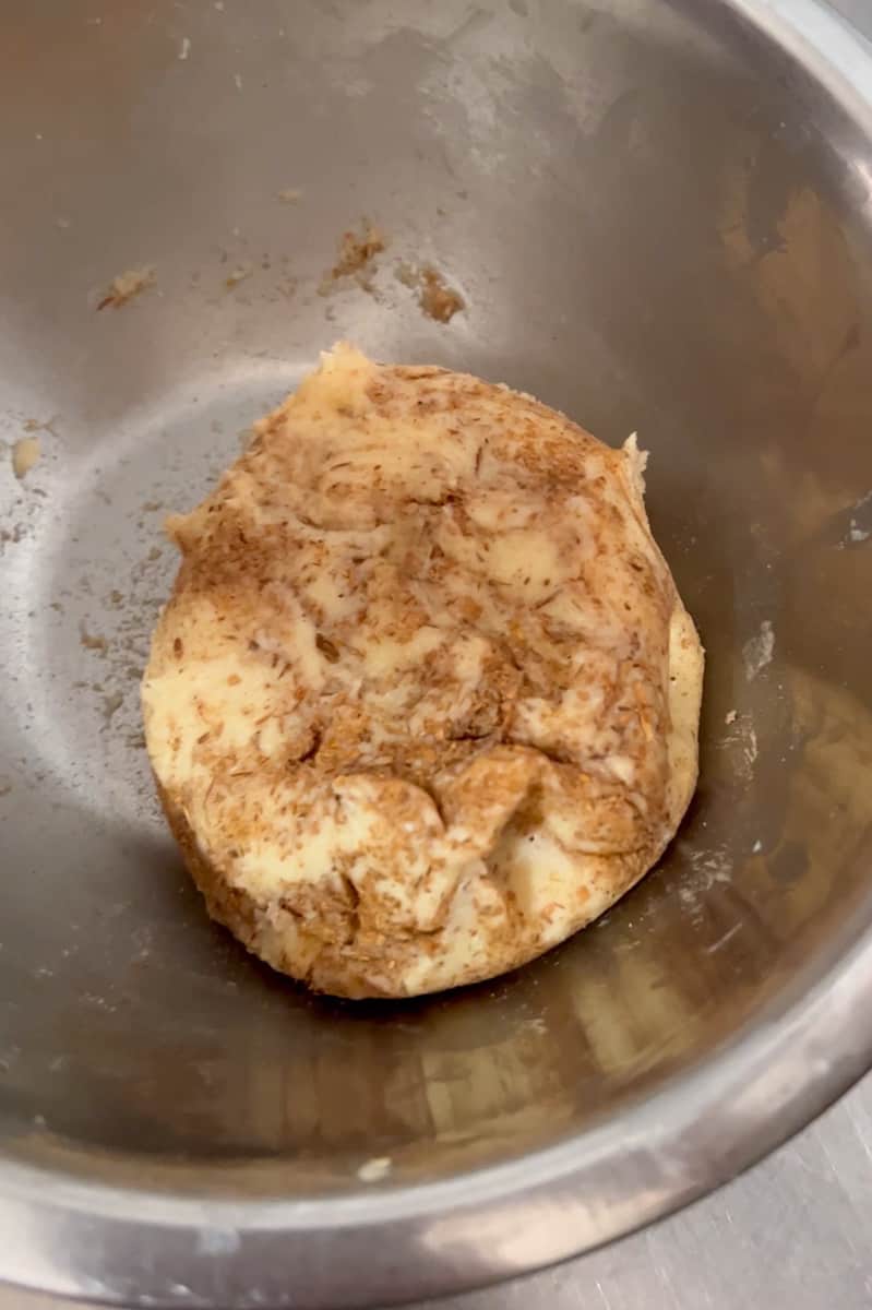 While this is rising, you can make the toppings for the conchas. We will be making a vanilla, chocolate and cinnamon topping. In the stand mixer, add the flour, butter and powdered sugar and mix. Divide this paste into three portions. For one, you will add the cacao and for the other one you will add the cinnamon. Mix each well. Now you have a vanilla, chocolate and cinnamon topping. Cover so it doesn't dry out.