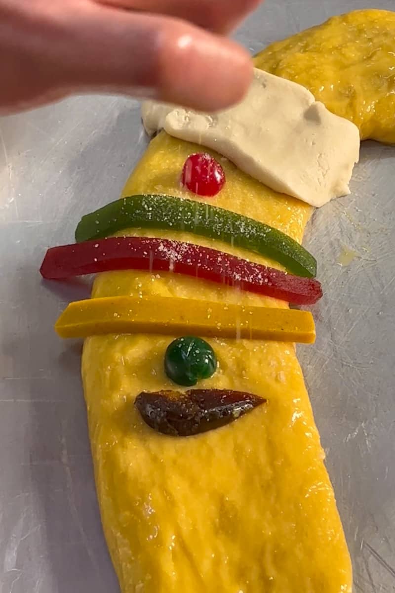 Bake the Rosca: Preheat the oven to 400°F (200°C). Brush both wreaths with a beaten egg. Remove the paste from the fridge and divide it into 8 long strips. On a lightly floured surface, use a strip to cover the seam and then evenly space the remaining strips around the wreath. Cover the strips with the the beaten egg and sprinkle them with sugar. Decorate the rest of the wreath with the sugar and candied fruit. Bake for about 25 to 30 minutes. Check after 20 minutes or so if the Rosca is getting too brown, cover with aluminum foil. Remove from the oven and once cooled, serve. 