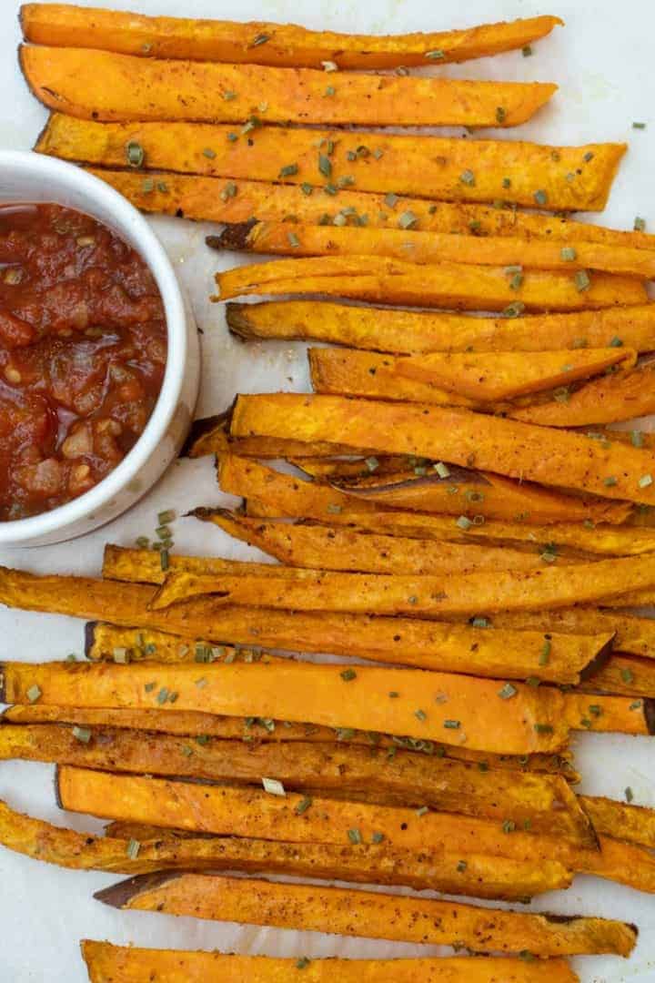 This Air Fryer Sweet Potato Fries Recipe is made of sweet potatoes, avocado oil spray, chives, Cajun seasoning, smoked paprika, and salt.