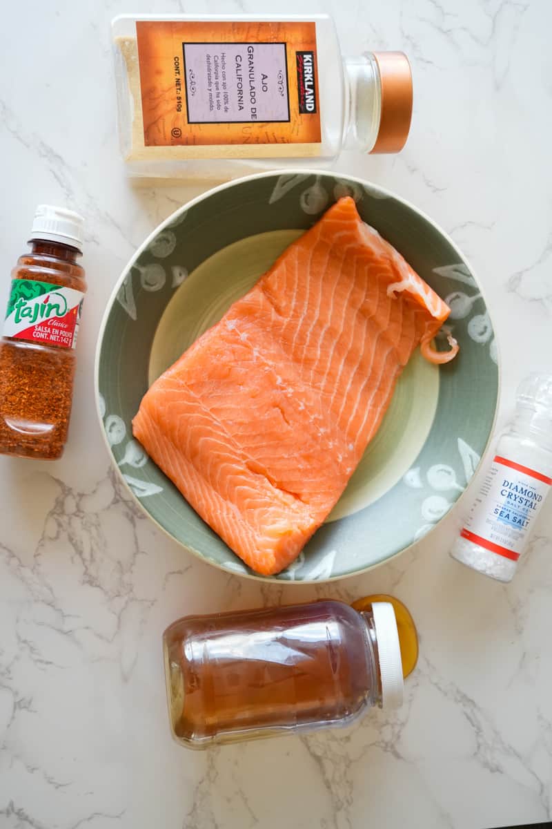This Spicy Baked Salmon Recipe is made with fresh salmon, Tajin, honey, garlic powder and baked to perfection. 