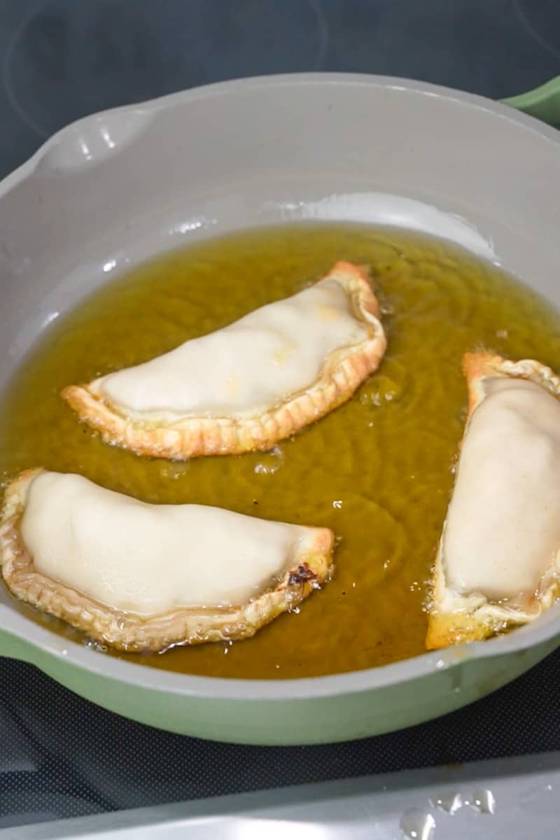 Pan Fry the Empanadas: In a skillet, add a cup of oil and heat it up on medium-high heat.  Fry them 2-3 minutes per side. Add on a coloring rack. 