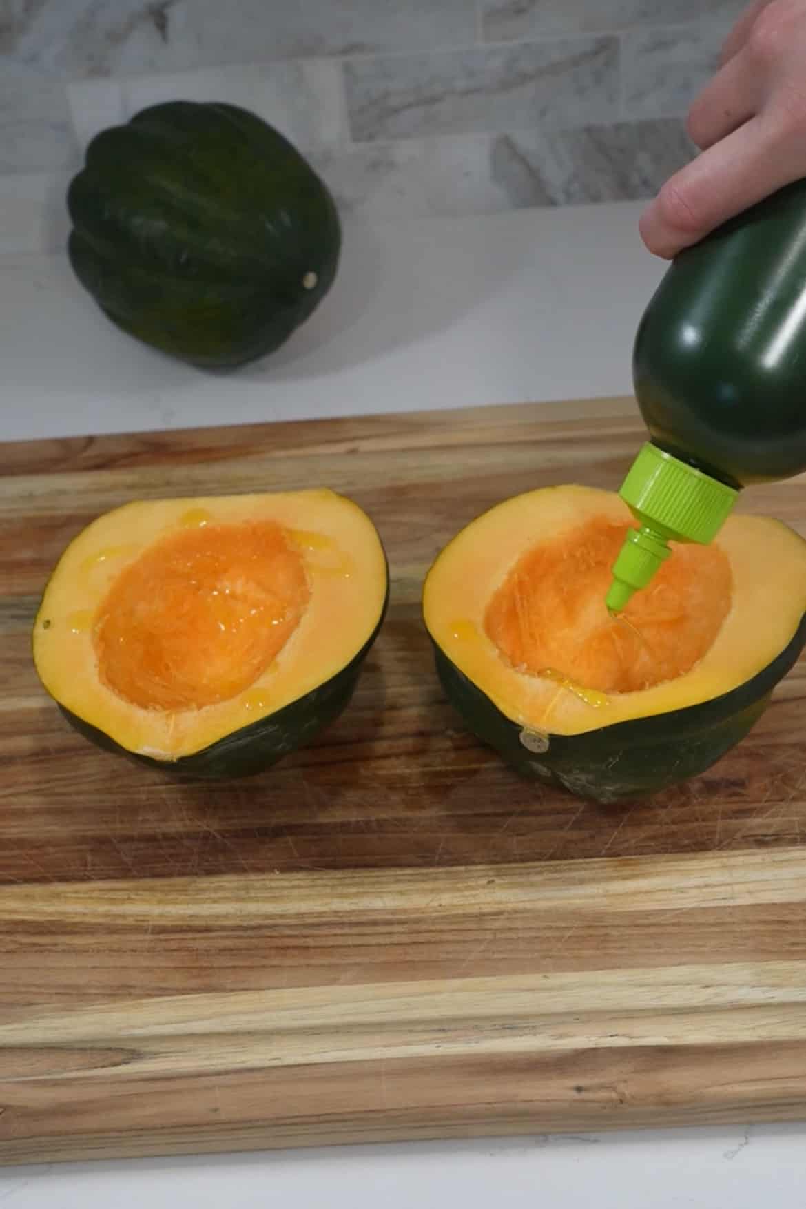 Cut the acorn squash in half horizontally and scoop out the seeds and strings. If necessary, trim a small slice off the bottom of each half to ensure they sit flat. Brush the cut sides of the squash halves with a little olive oil and season with salt and pepper.
