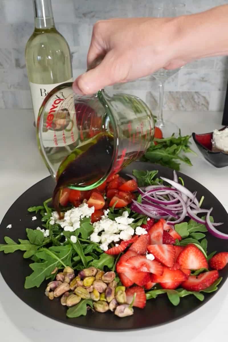 Drizzle the dressing over the salad and toss gently to coat. Top with crumbled goat cheese and pistachios.